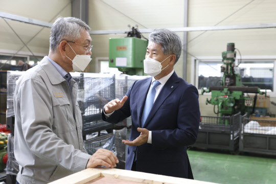 윤종원(오른쪽) 기업은행장이 지난 6월 29일  거래 중소기업을 방문해 생산 공정에 대해 설명을 듣고 있다. 기업은행 제공